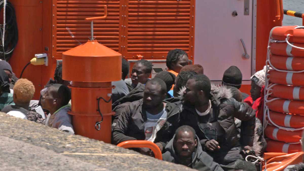 Flyktingar sittande i räddningsbåt
