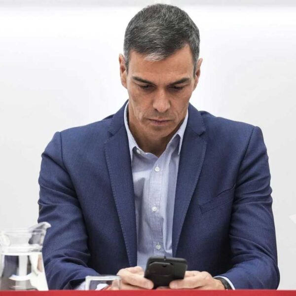 President Sanchez läser på mobilen