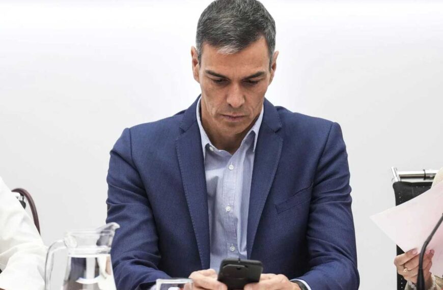 President Sanchez läser på mobilen