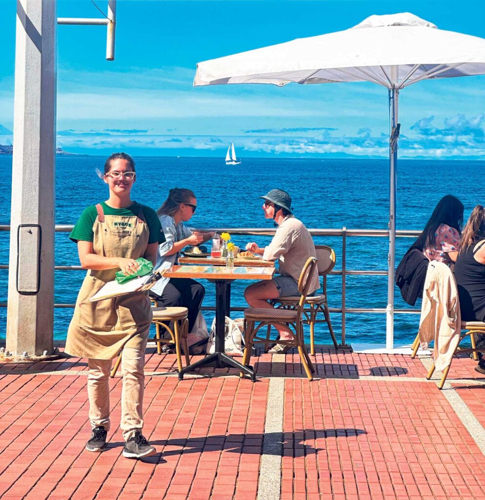 Servitör med havet i bakgrunden