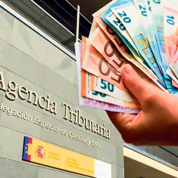 Hand med pengar framför hacienda